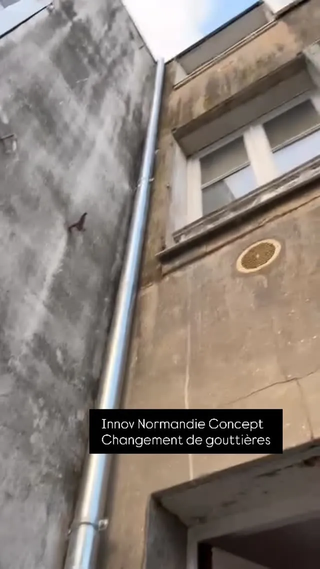 Descente de gouttière en zinc neuve posée sur une façade ancienne